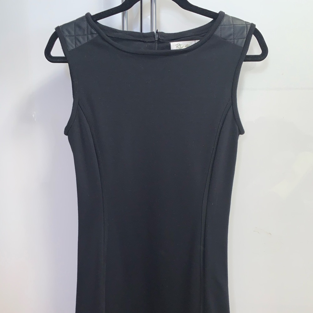 Short black tunic with leather like effects around shoulders and hemline
